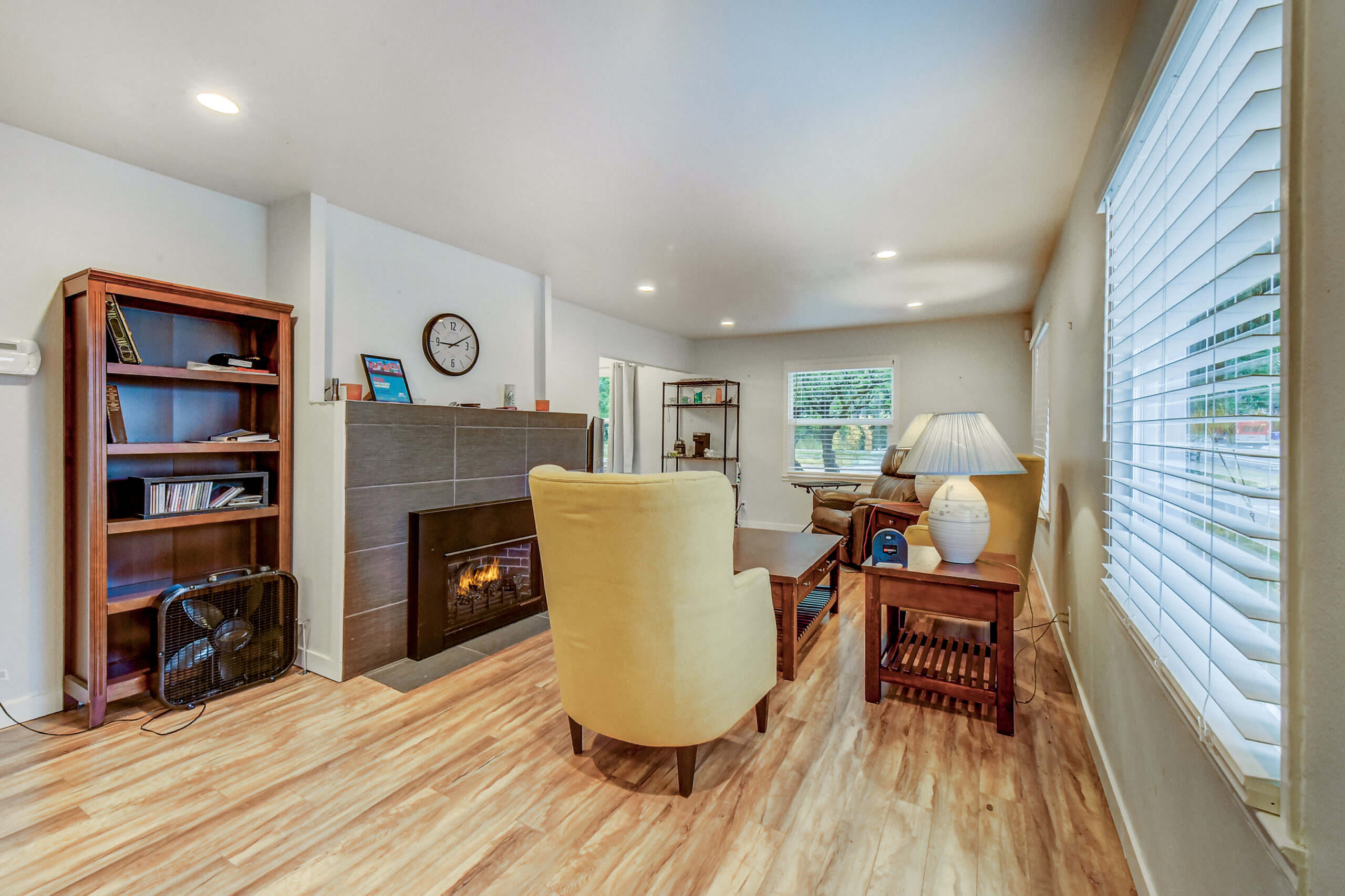 Living room with tiled fireplace and wood flooring at the Everett rambler, 624 Madison St