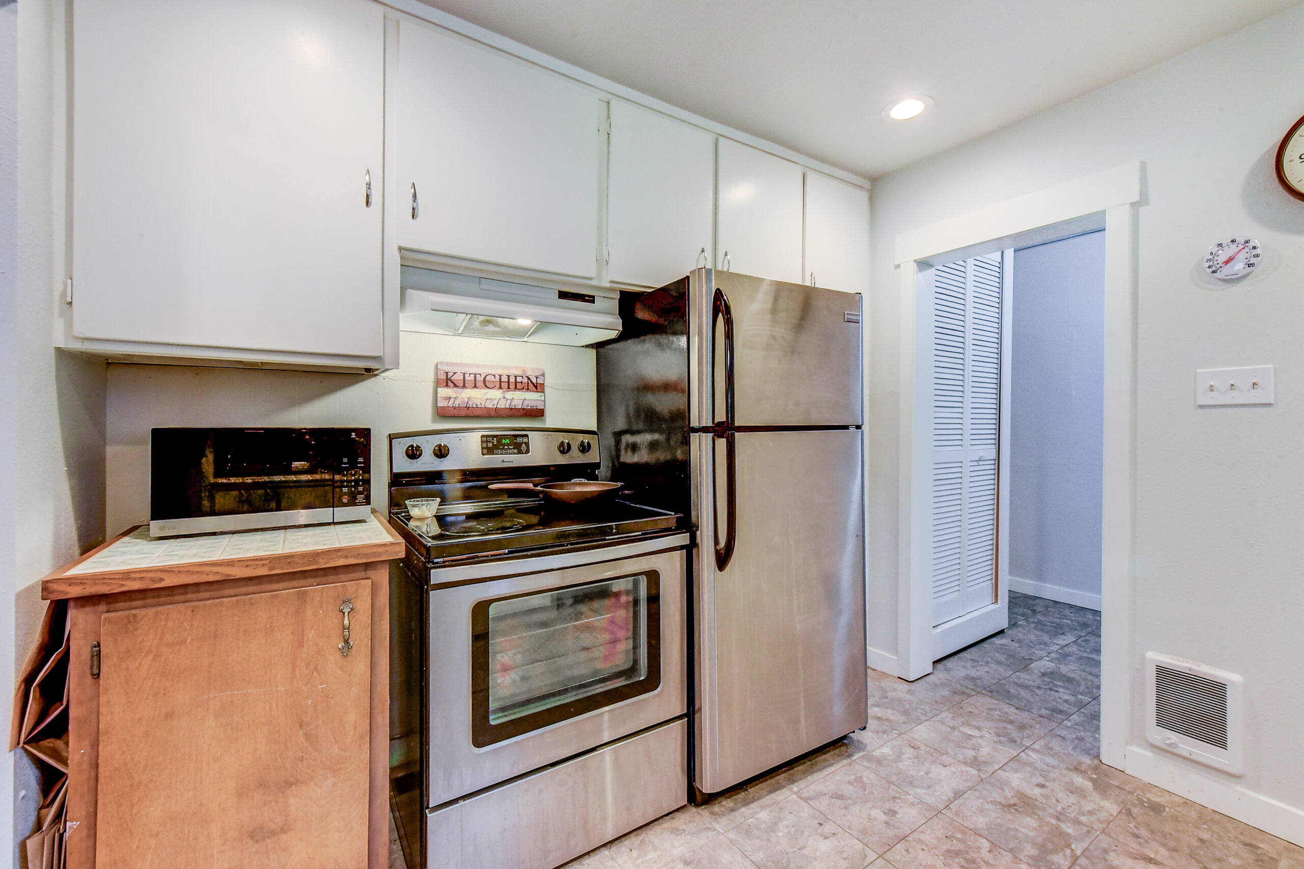 Kitchen with stainless range and refrigerator at the Everett rambler on Madison St