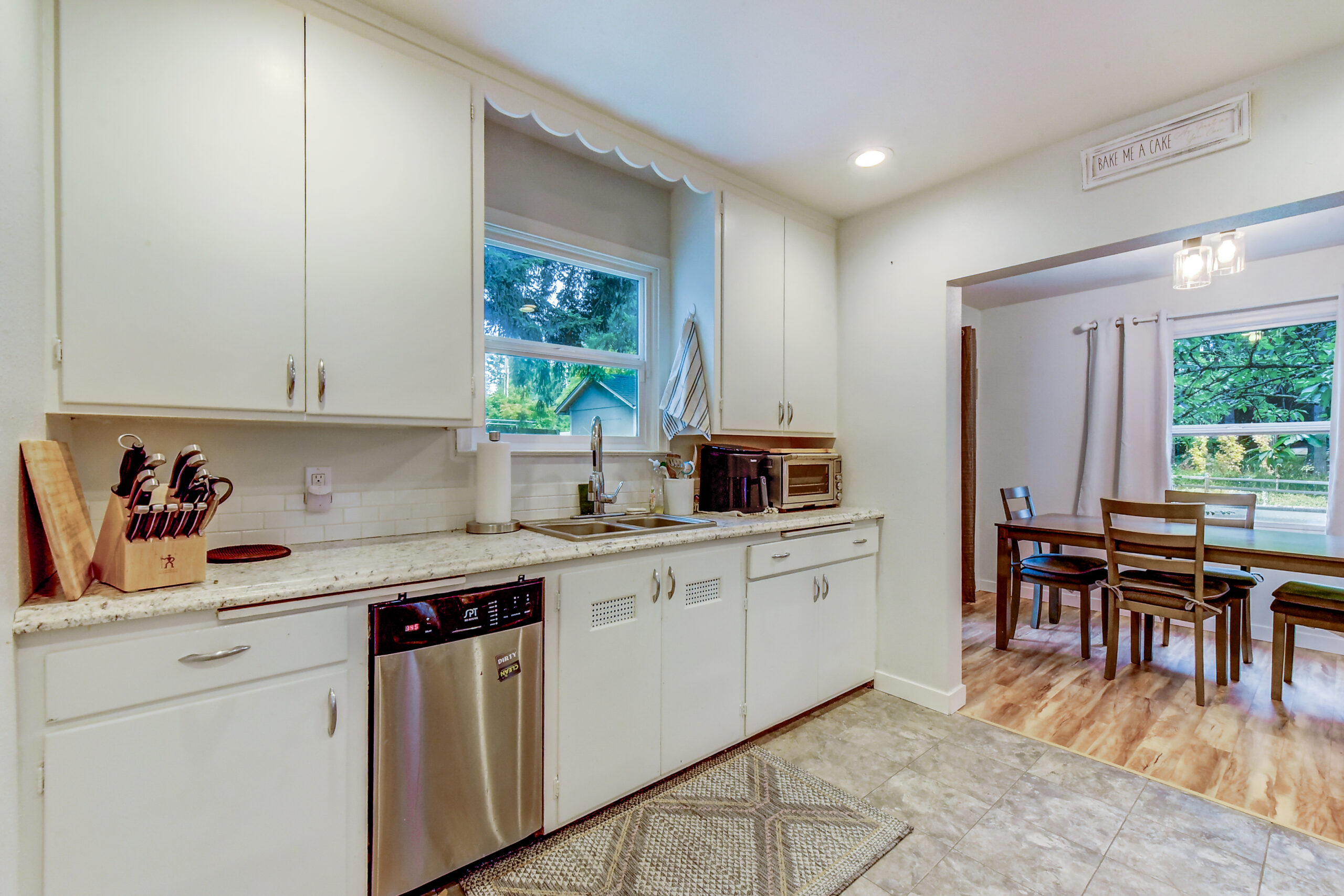 Kitchen with white cabinets and dining nook in the Everett rambler at 624 Madison St