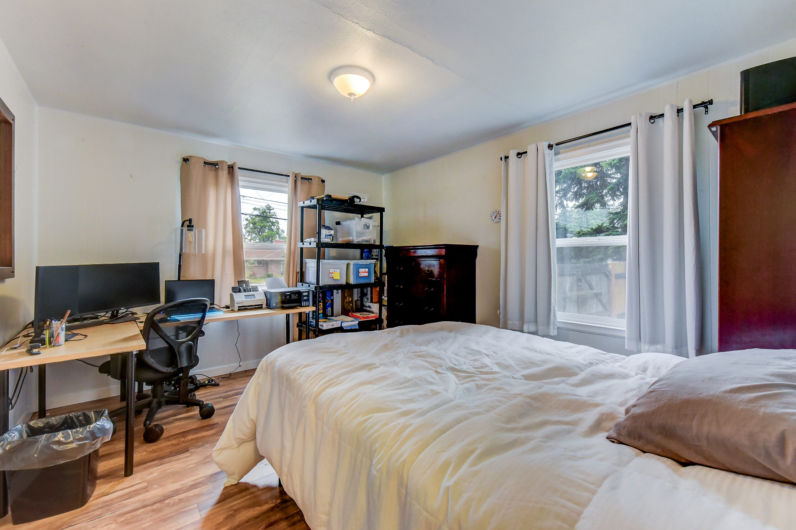 Bedroom with desk, dresser, and windows at the Everett rambler on Madison St
