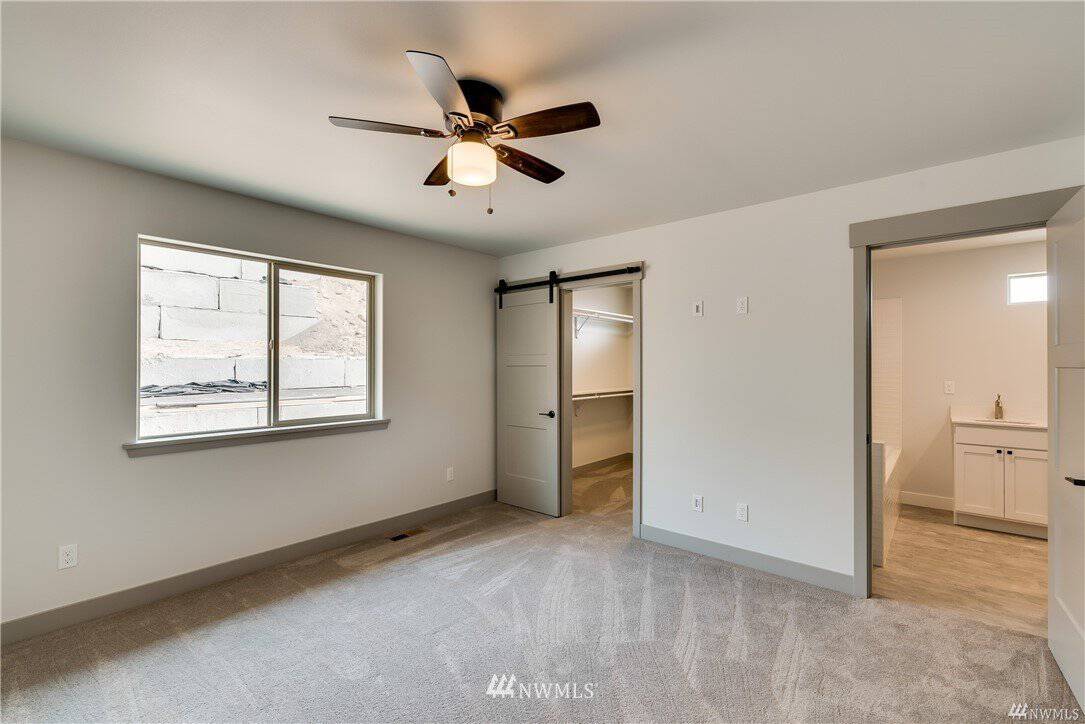 Primary bedroom with walk-in closet and ensuite bath at the Entiat rambler home