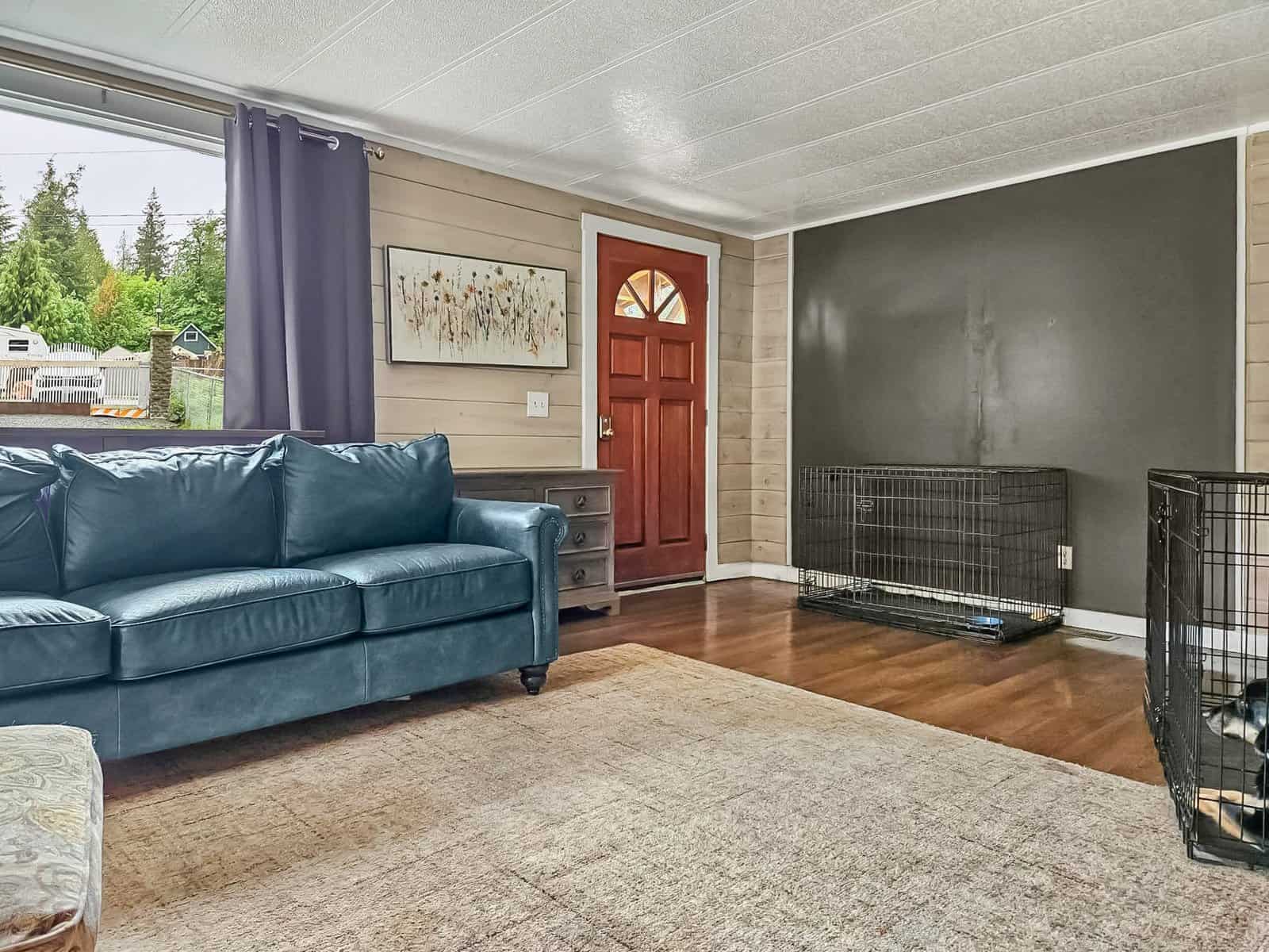 Living room with leather sofa, front door, and shiplap wall in the Concrete, WA home