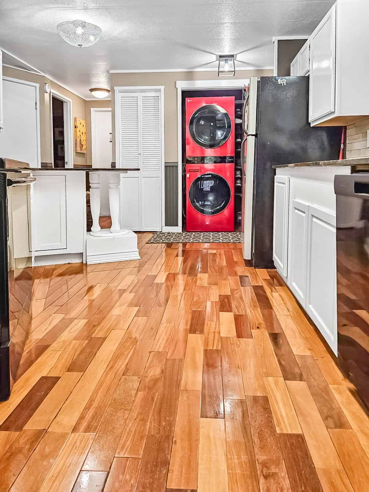 Kitchen with stacked red washer-dryer and wood flooring at the Concrete, WA rent-to-own home