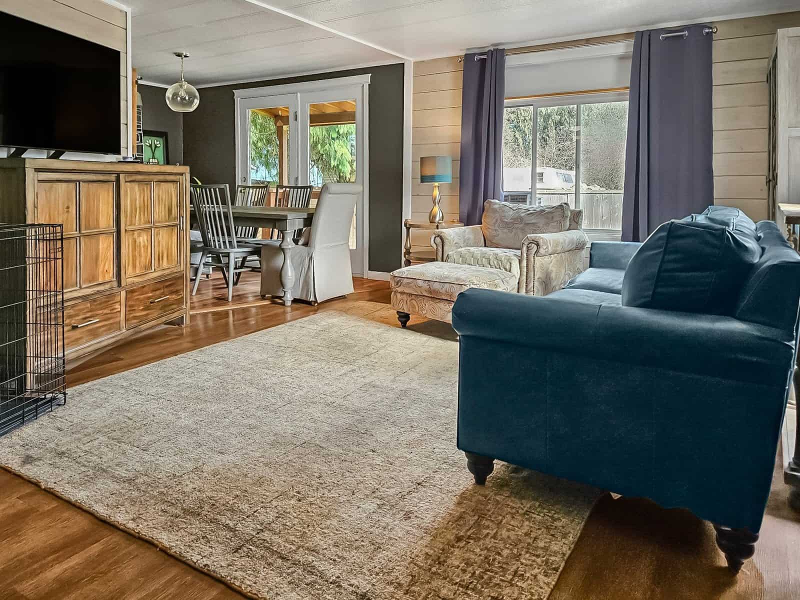 Living room and dining area of the Concrete home, with sofa, TV, and door to covered deck