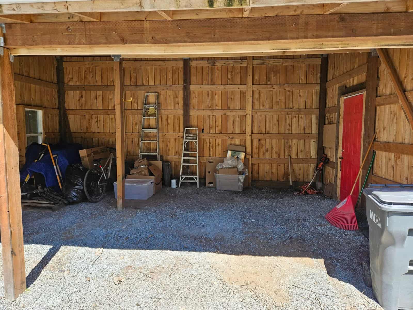 Two-bay carport and storage outbuilding at the Concrete, WA property, with tools and gravel flooring