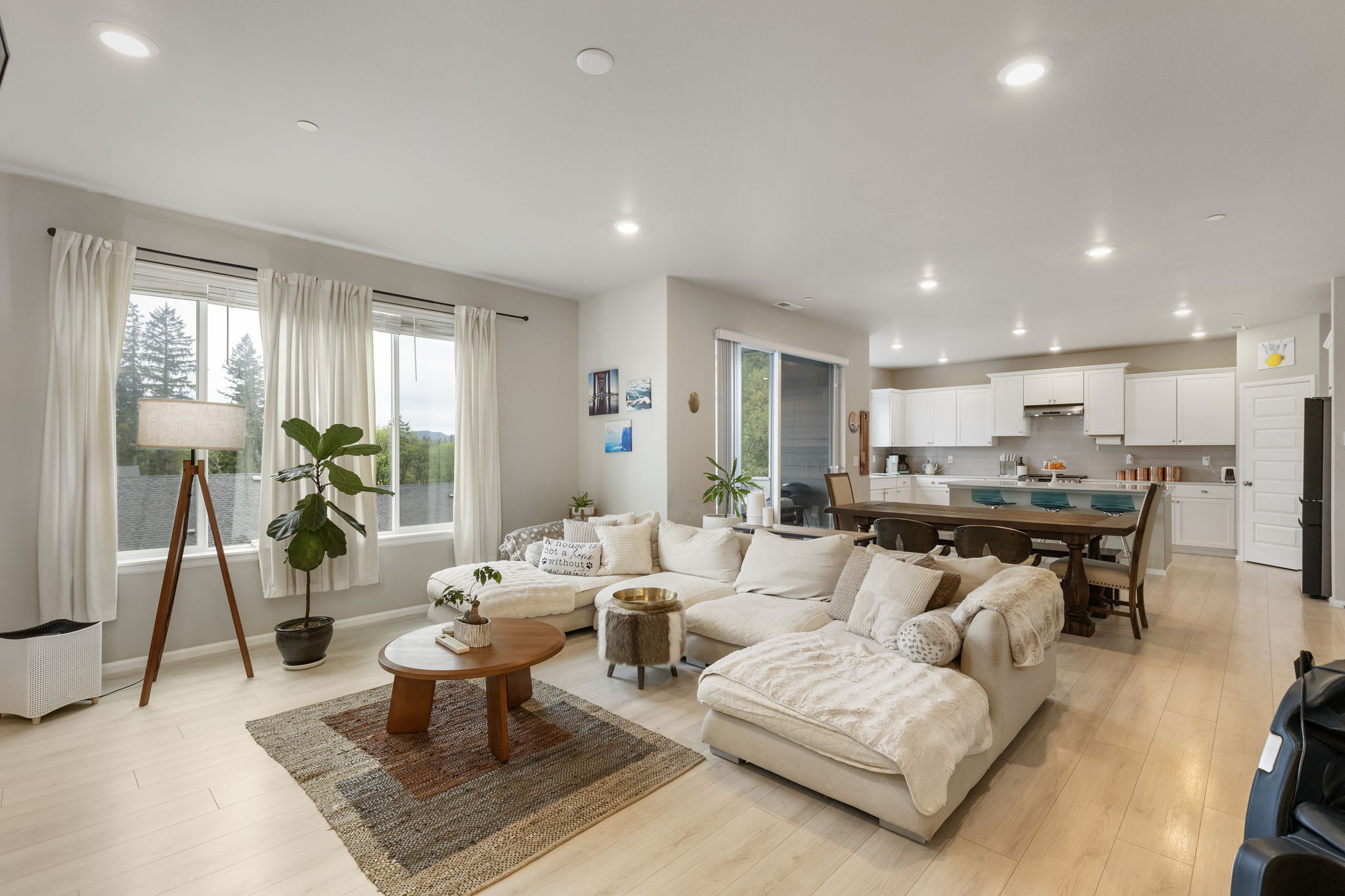 Open living room and kitchen area in the Port Orchard rent-to-own home, with sectional sofa and dining space