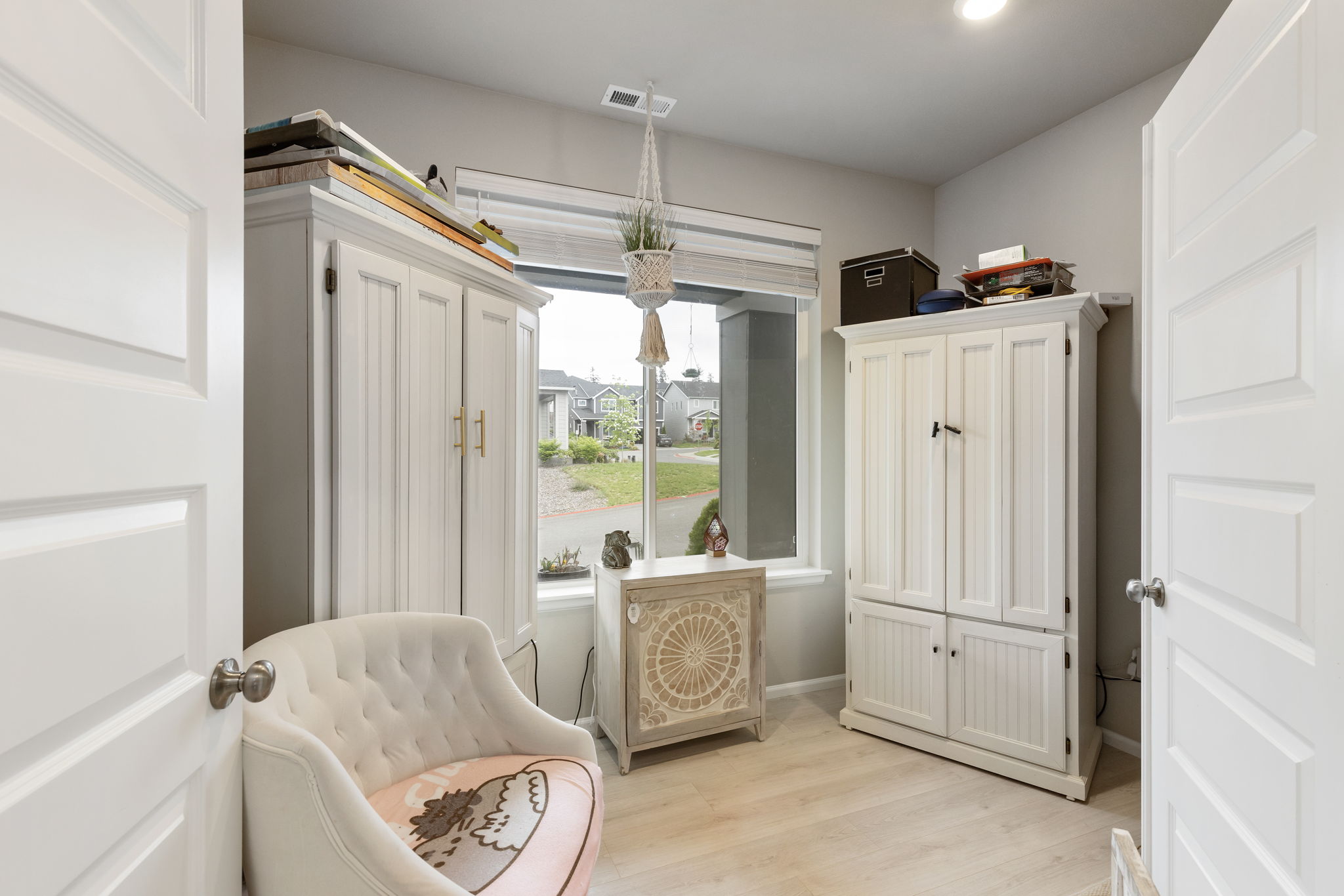 Bedroom with white armoires and window view at the Port Orchard rent-to-own home