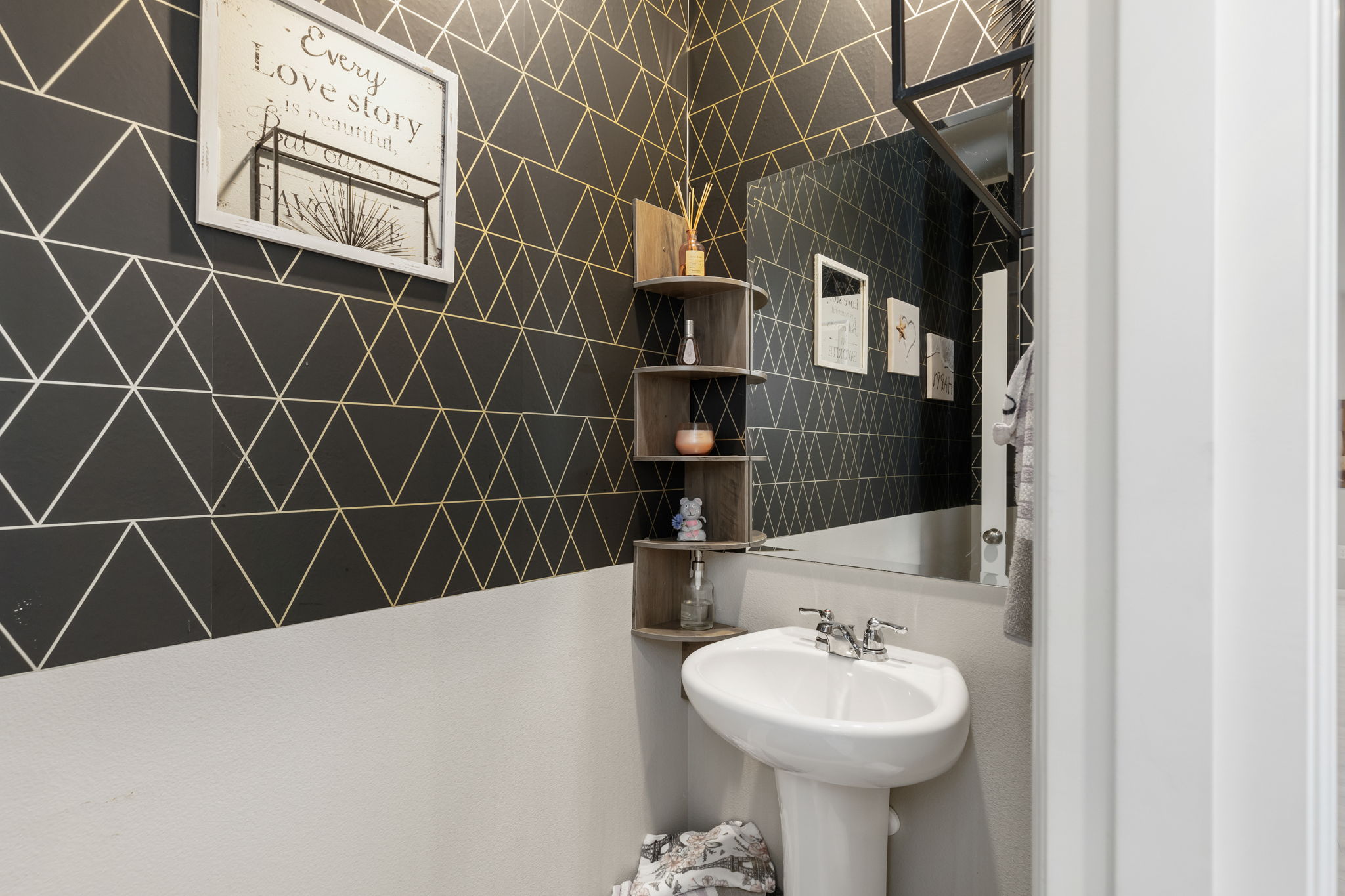 Powder room with geometric wallpaper and pedestal sink in the Port Orchard rent-to-own home