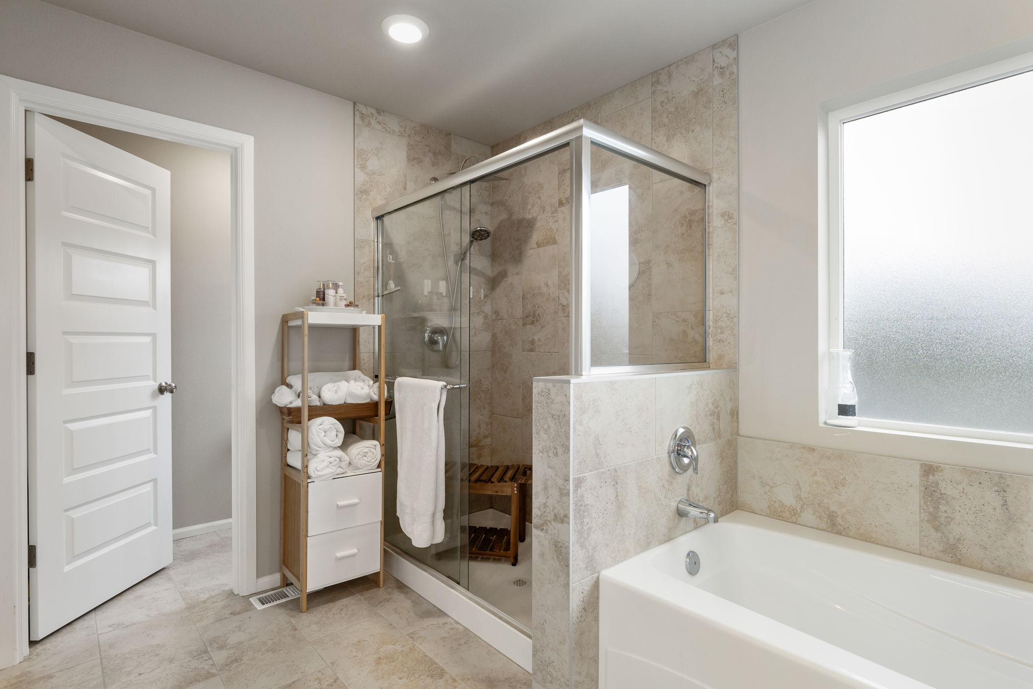 Primary bathroom with glass-enclosed shower and soaking tub at the Port Orchard rent-to-own home