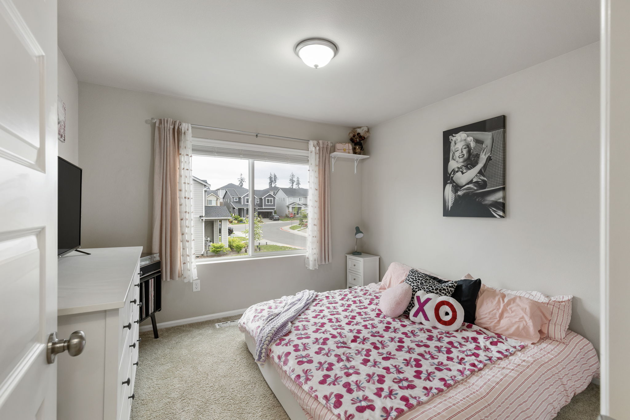 Bedroom with large window and neighborhood view in the Port Orchard home at 962 Thrush Ct SE