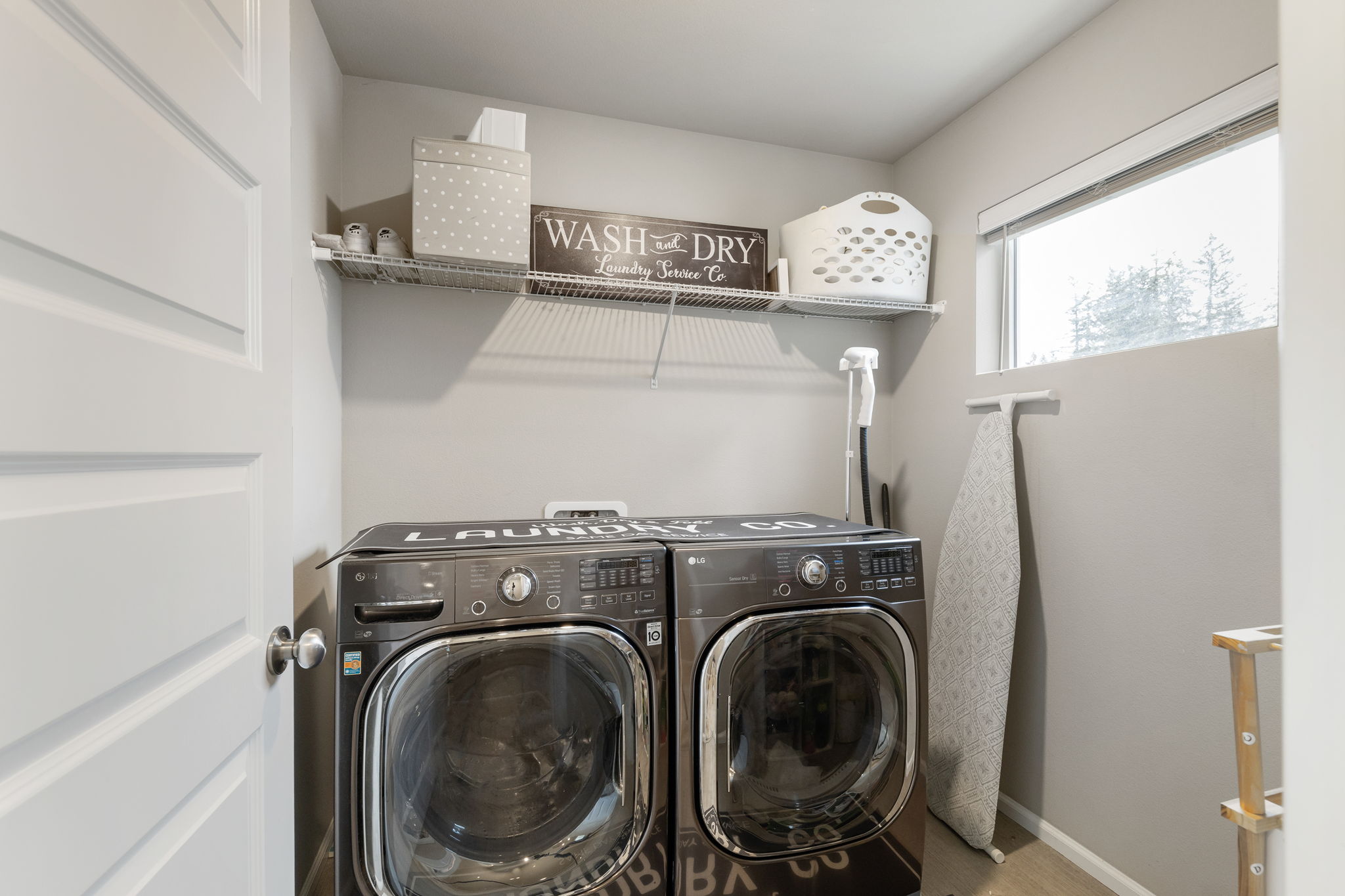 Laundry room at 962 Thrush Ct SE Port Orchard with LG washer/dryer set, shelving, and window