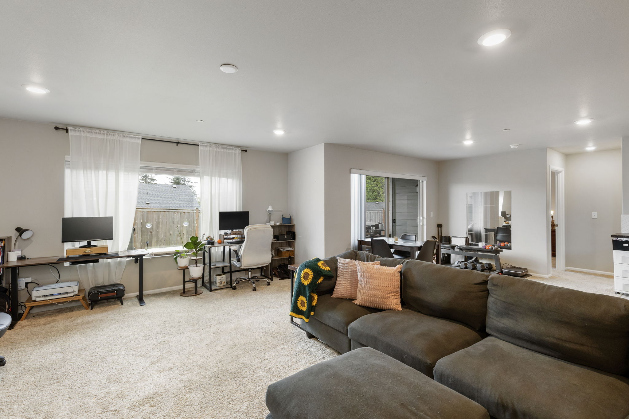 Basement family room with dual desks and sectional sofa in the Port Orchard rent-to-own home