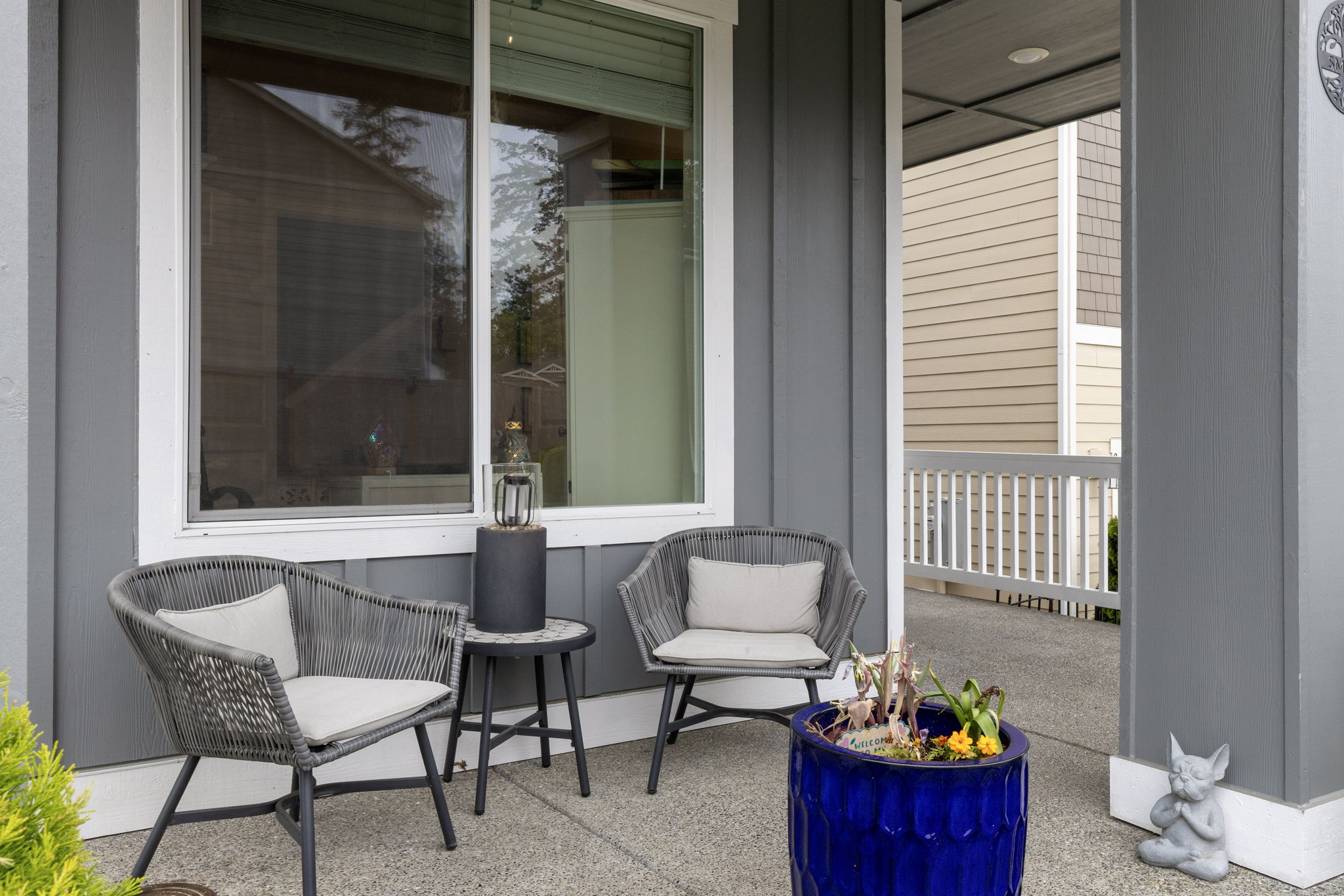 Front porch seating area with woven chairs at the Port Orchard rent-to-own home on Thrush Ct