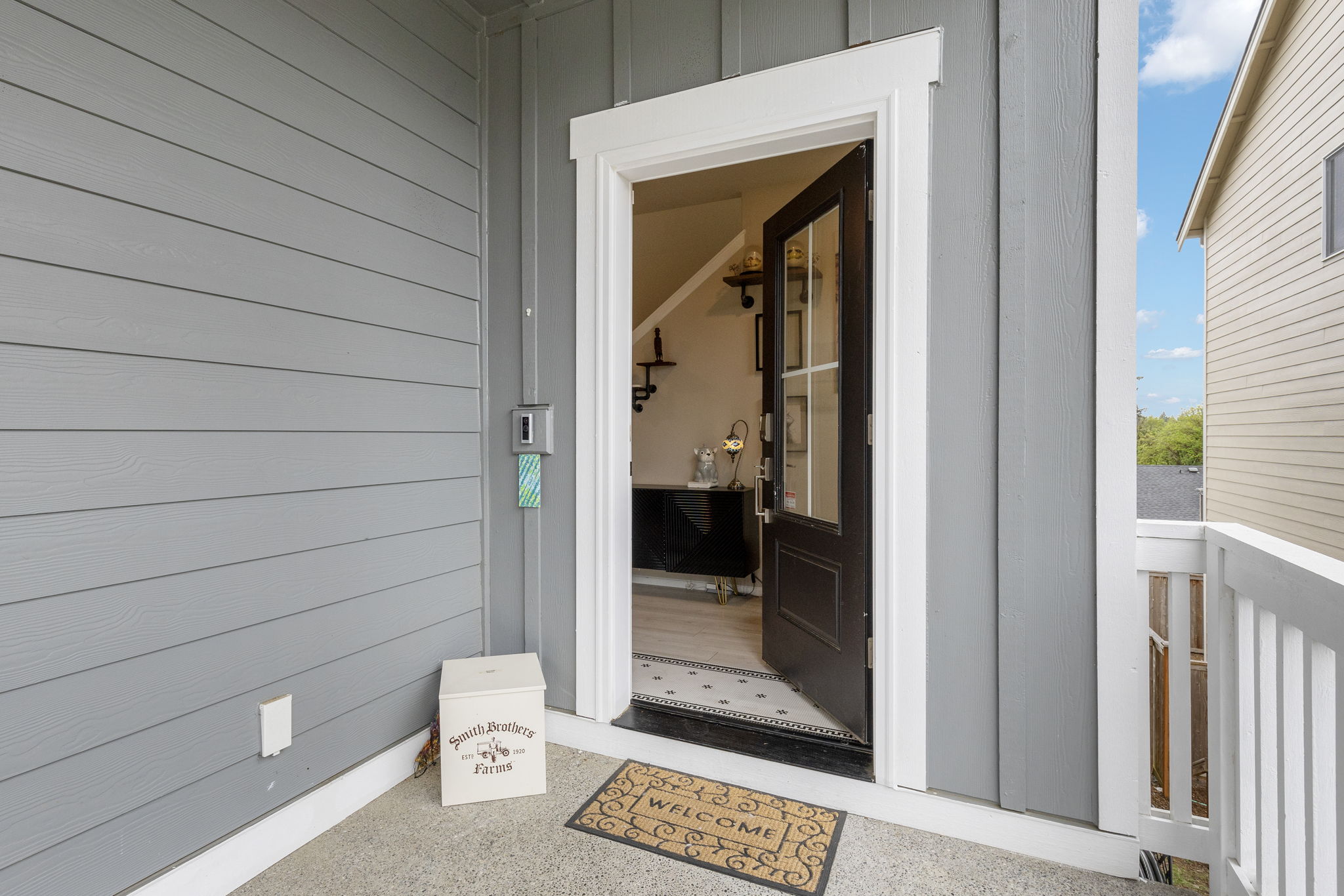 Front entrance with open door and welcome mat at the Port Orchard rent-to-own home, 962 Thrush Ct SE