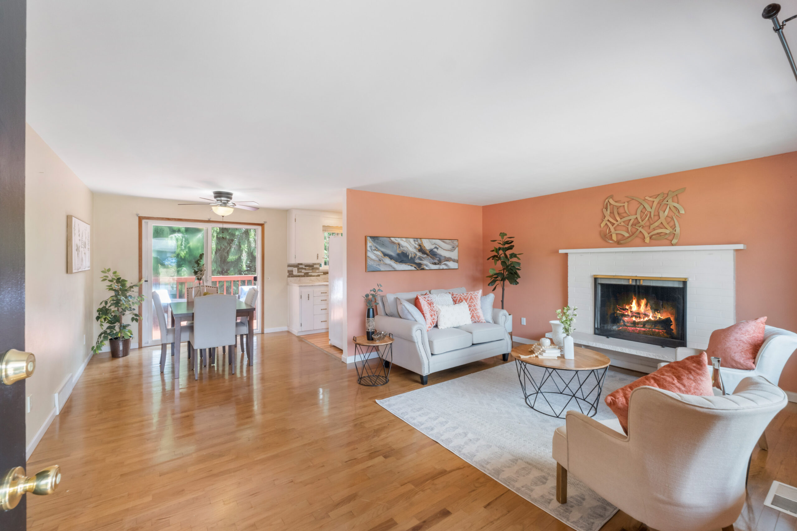 Living room with fireplace and open dining area in the upstairs unit of the Auburn duplex