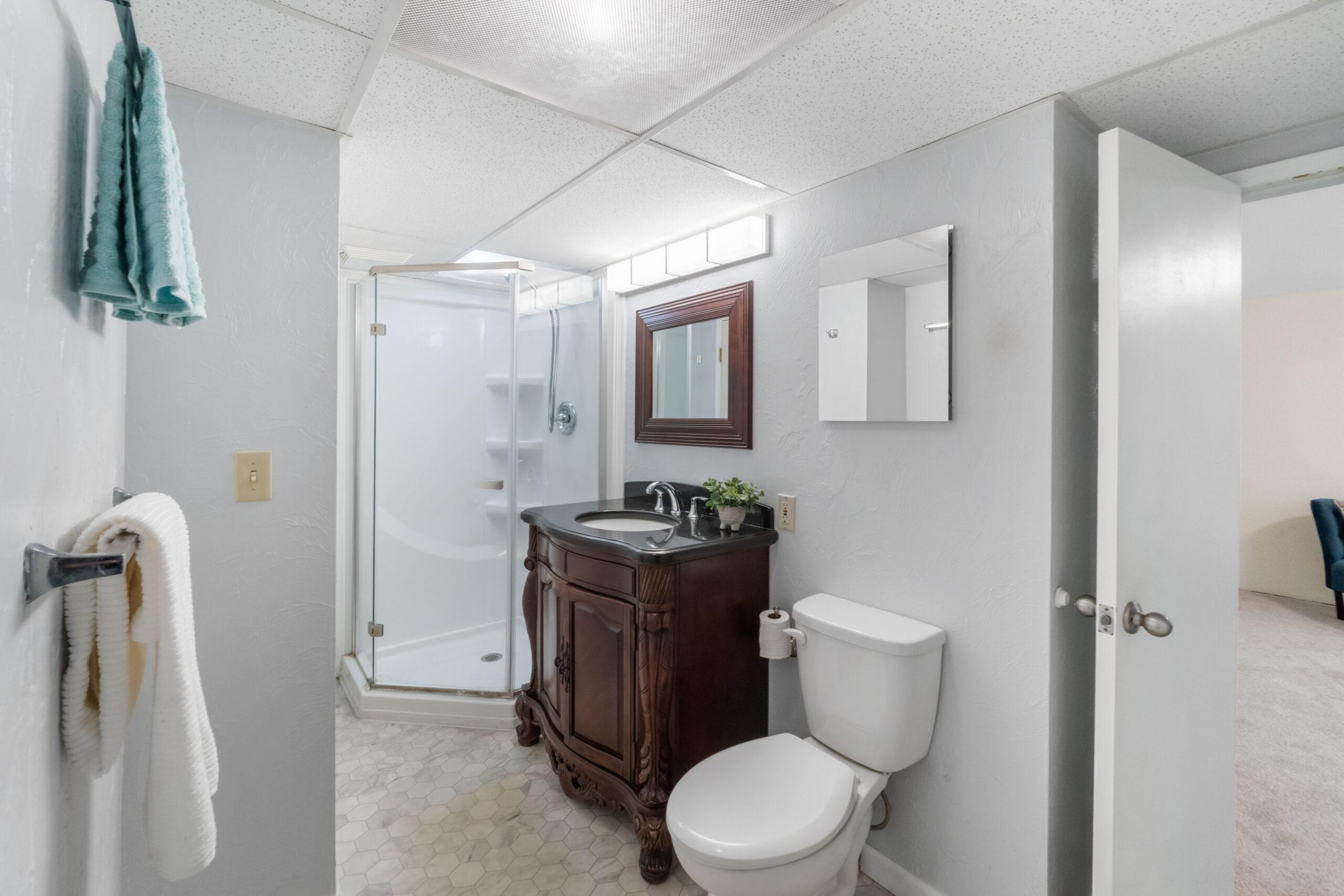 Full bathroom with glass shower stall and wood vanity in the Auburn duplex's downstairs unit