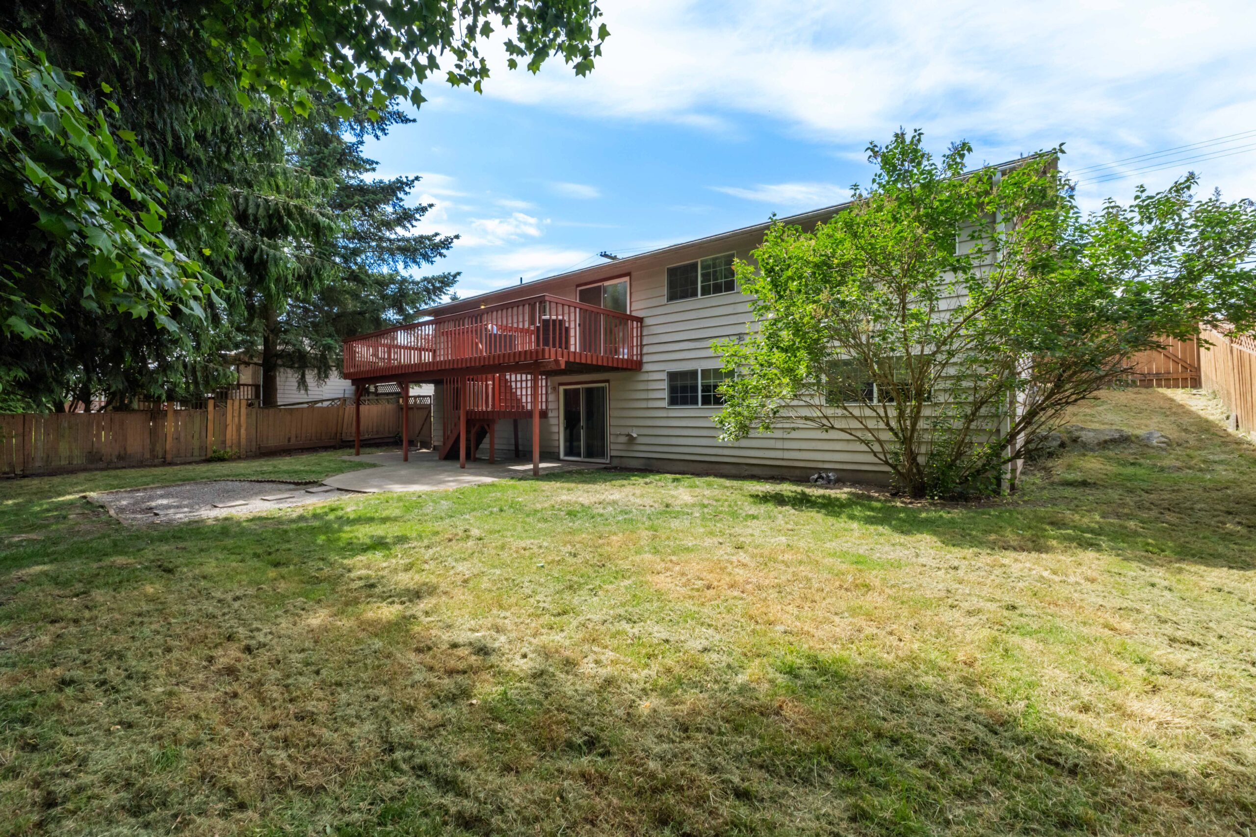 Backyard with large deck and fenced lawn at the Auburn duplex, private entrance below