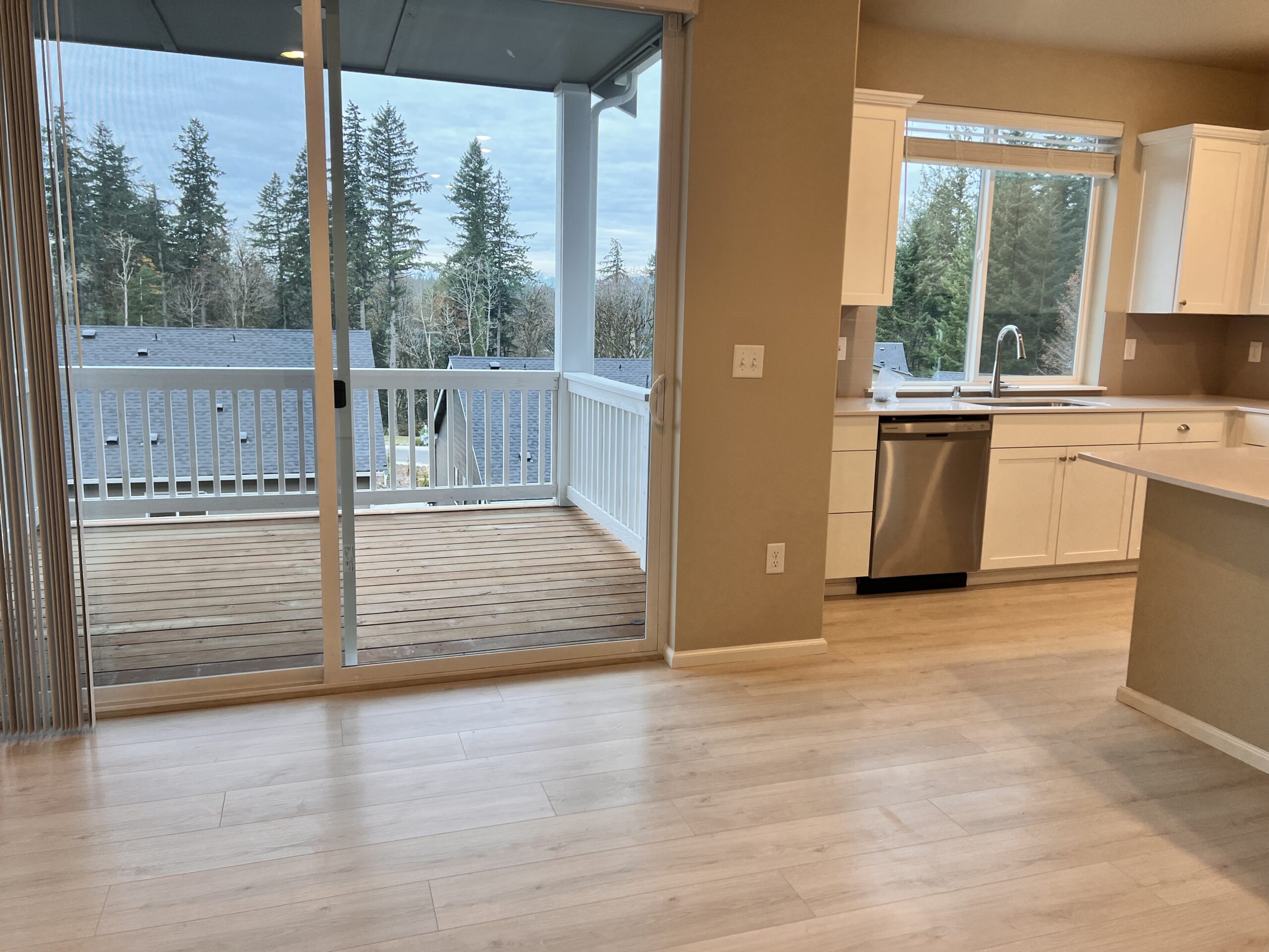 Kitchen and deck access at the Port Orchard rent-to-own home, with wooded views from the balcony